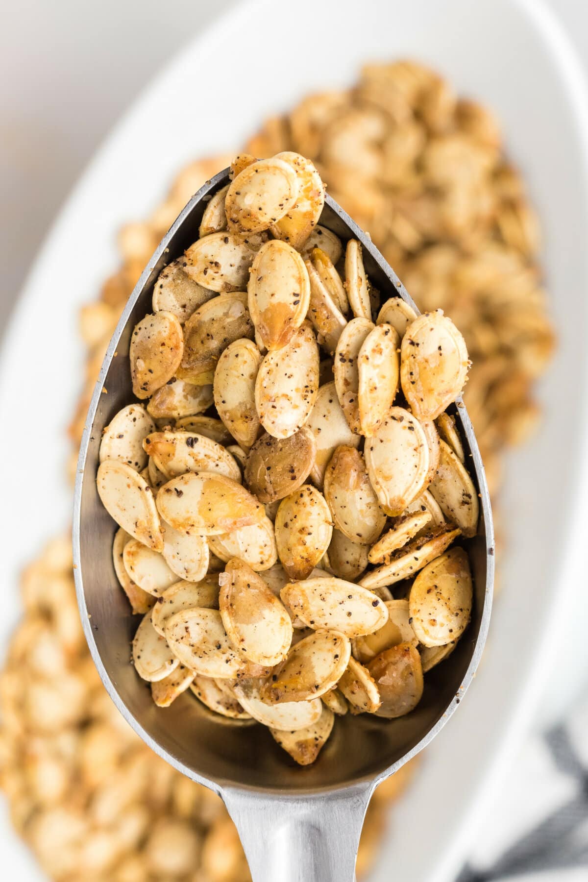 Air Fryer Pumpkin Seeds lifted up with a spoon.