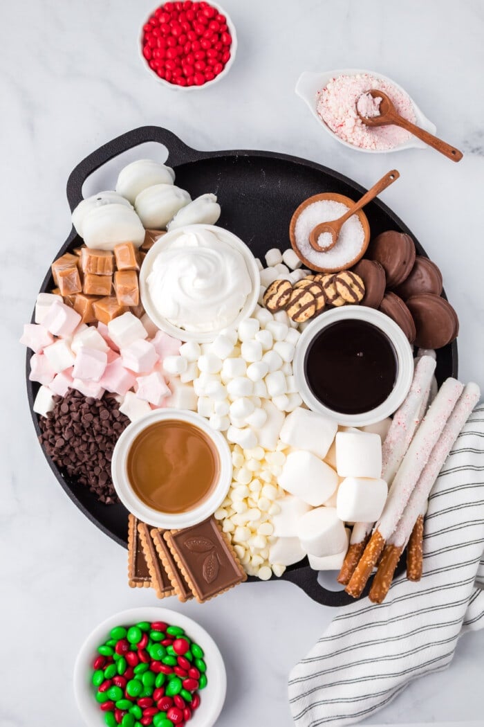 Assorted cookies are added to a hot chocolate charcuterie board.
