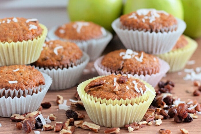 Morning Glory Muffins in colorful muffin wrappers with green apples in the background.