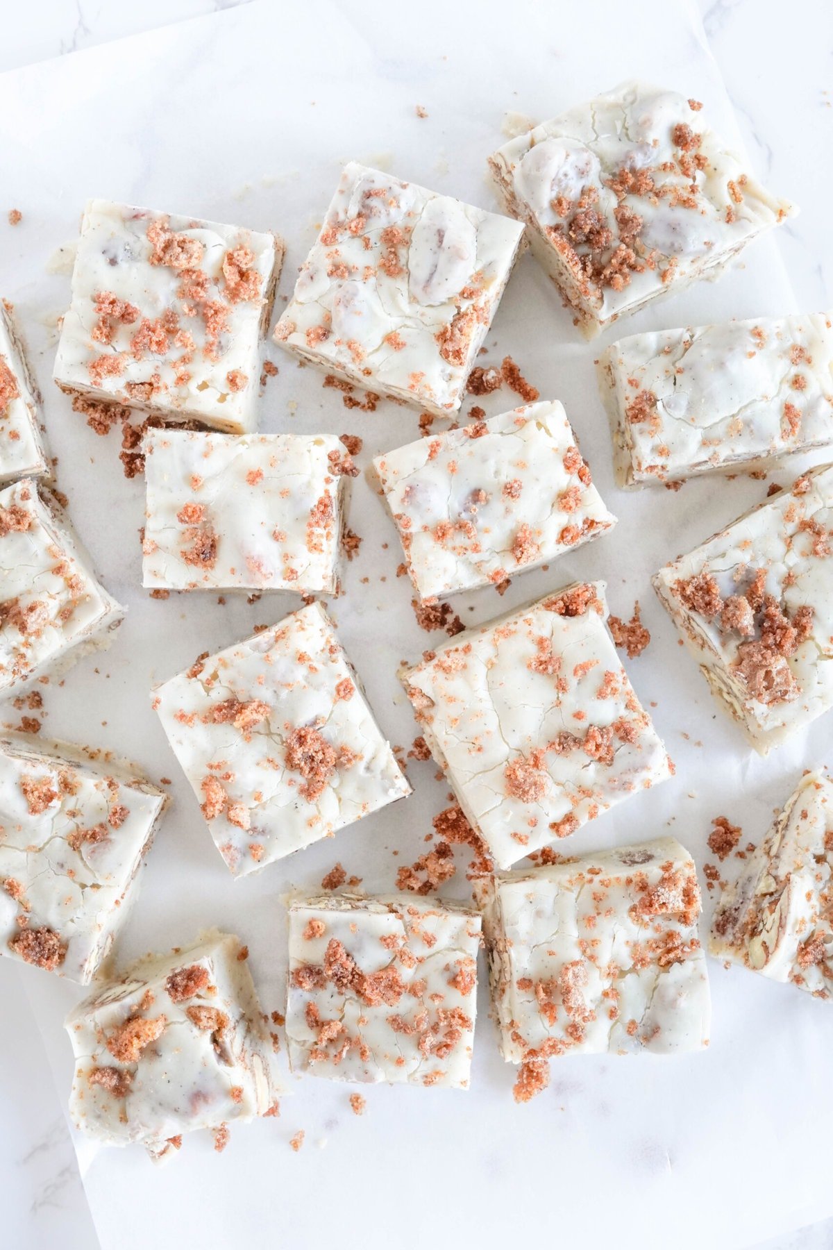 Squares of Pecan Fudge on a white table.