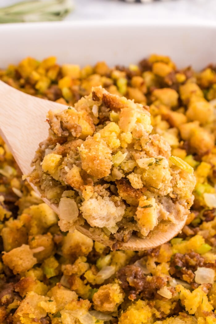 A spoon lifting up the Sausage Stuffing Recipe.