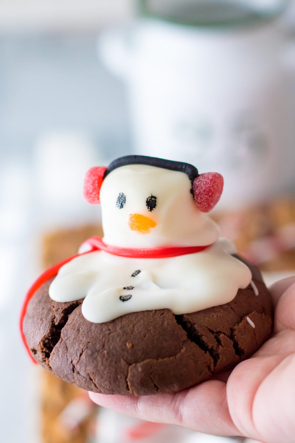 A hand holding a Snowman Cookie.