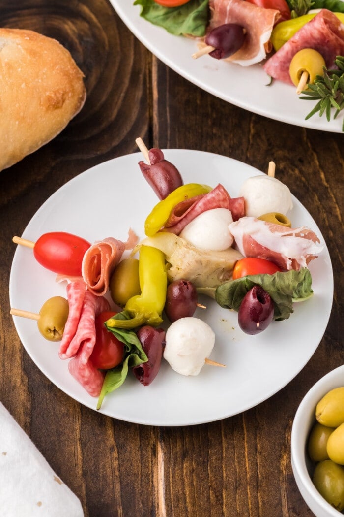 Two skewers of Antipasto Wreath on a plate.