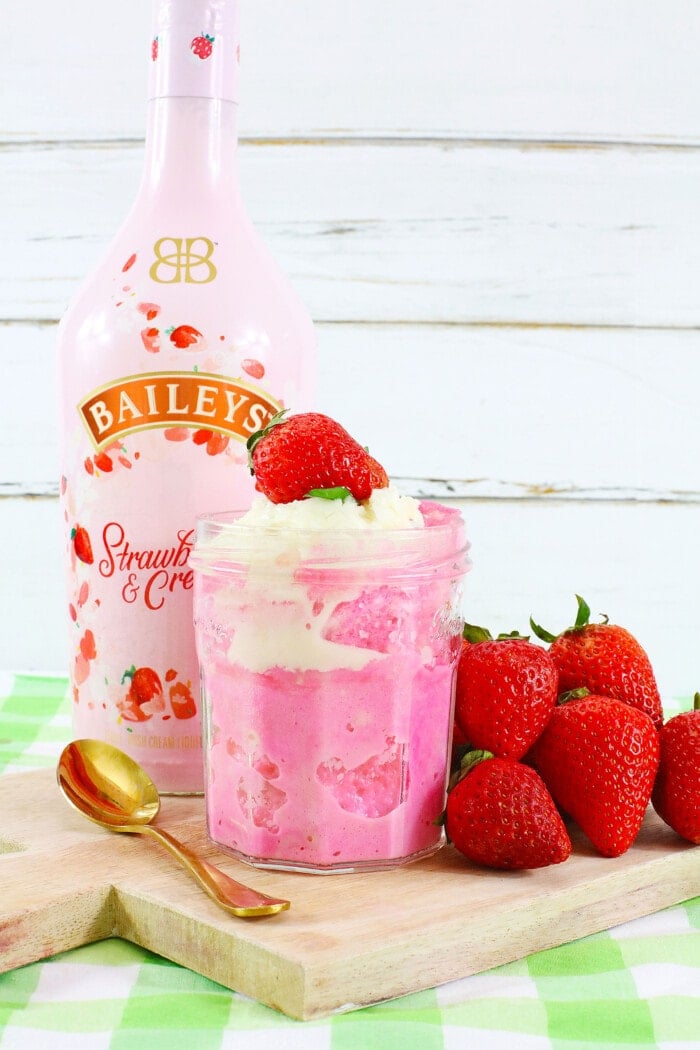 Bailey's Strawberry Mug Cake with whipped cream and a fresh strawberry on top.