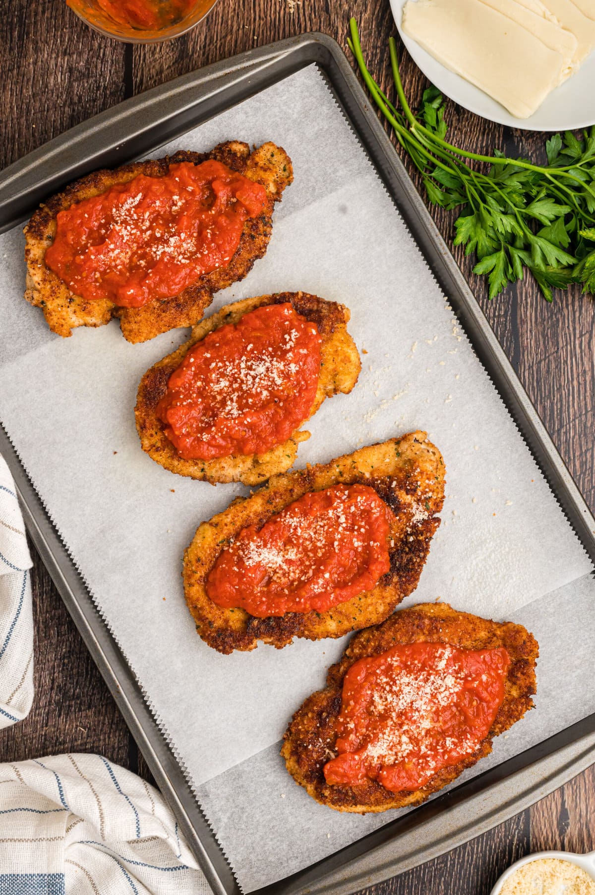 Fried chicken breasts topped with marinara sauce