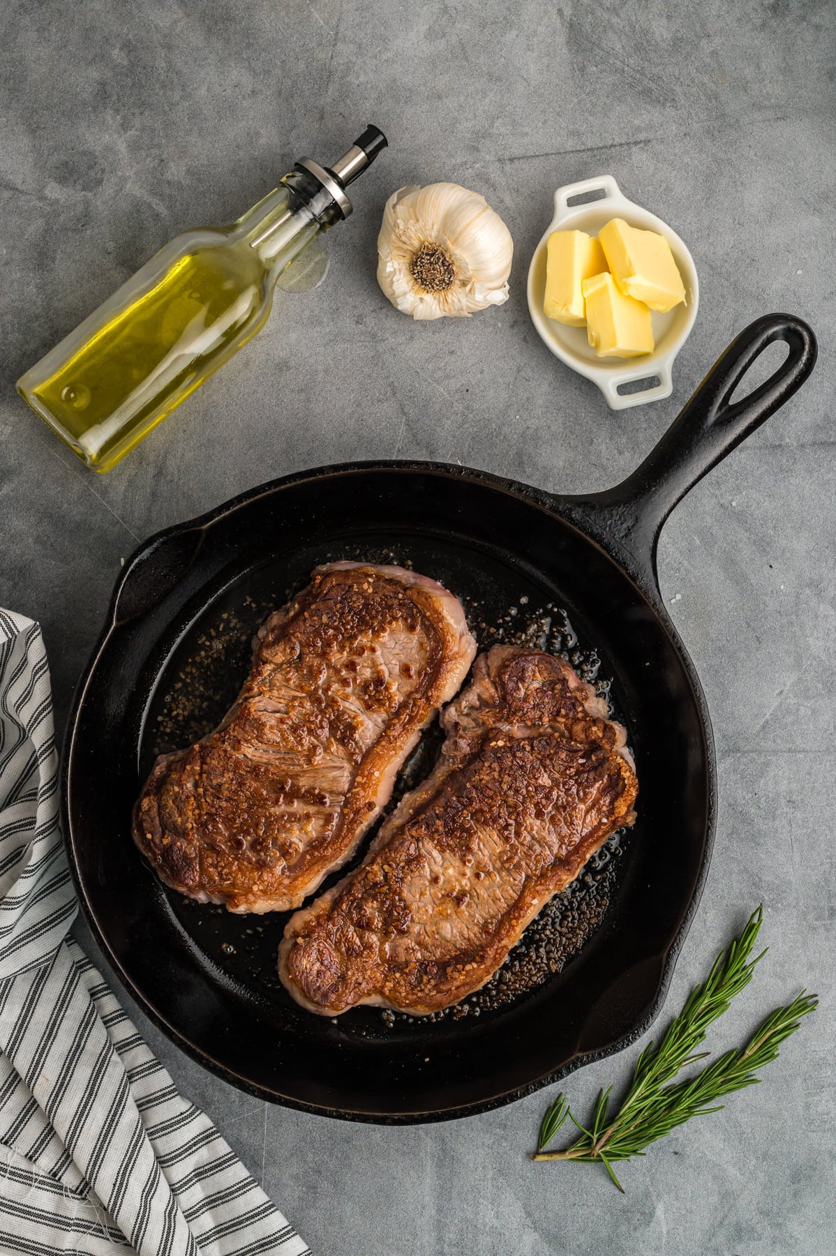 Two seared steaks in a cast iron skillet
