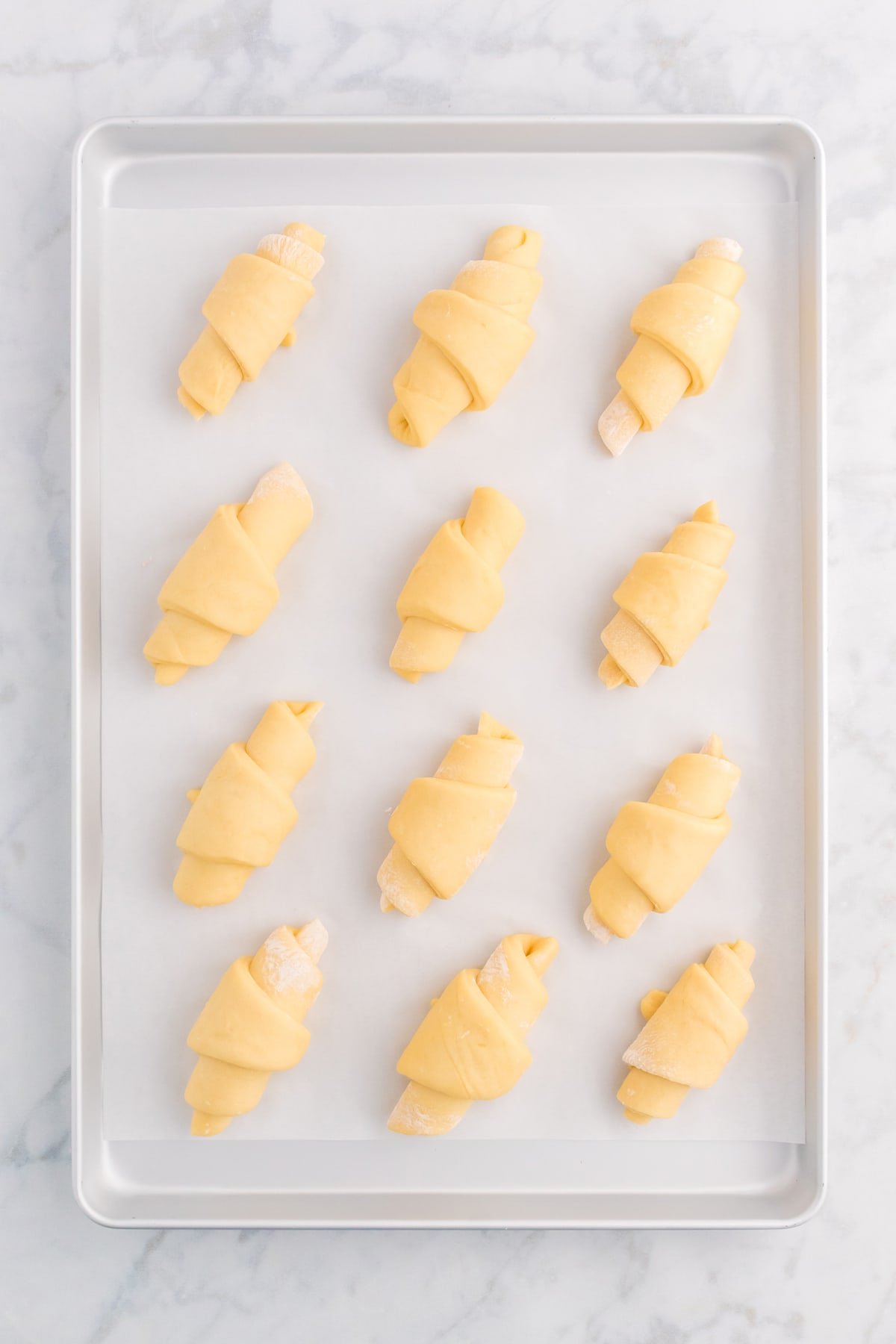 Unbaked crescent rolls on a baking sheet