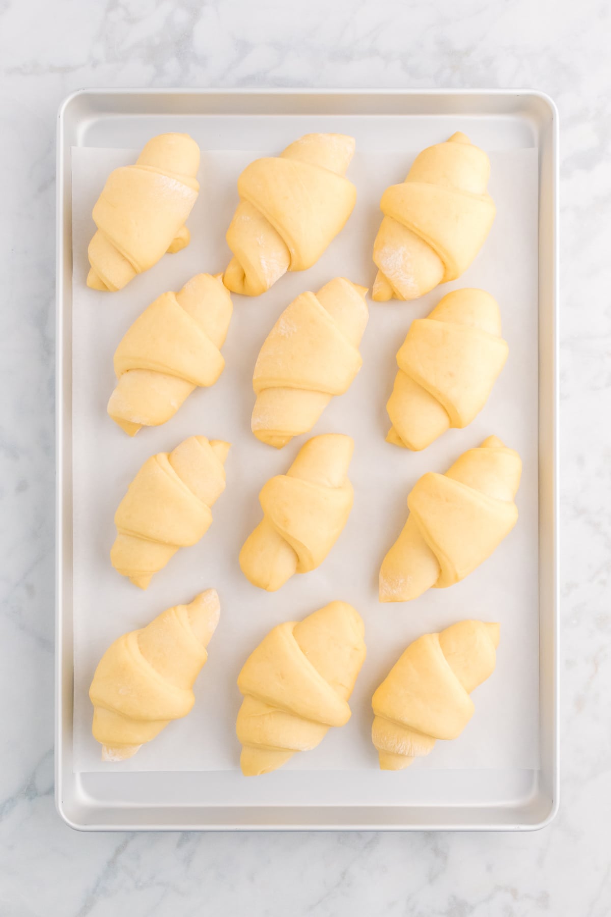 Unbaked crescent rolls on a baking sheet