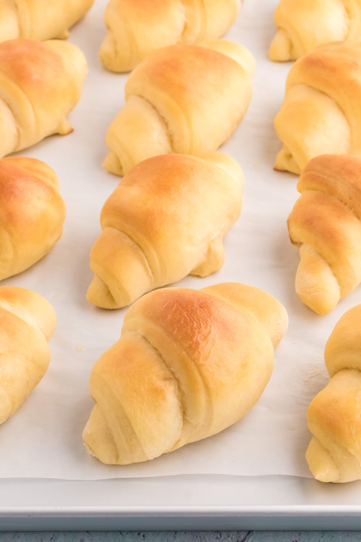 Angled view of a baking sheet of homemade crescent rolls
