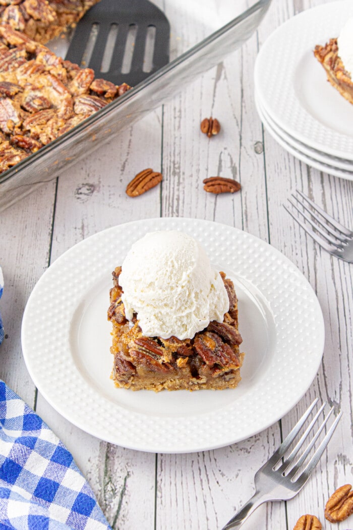 Pecan Pie Bars with ice cream on a plate.