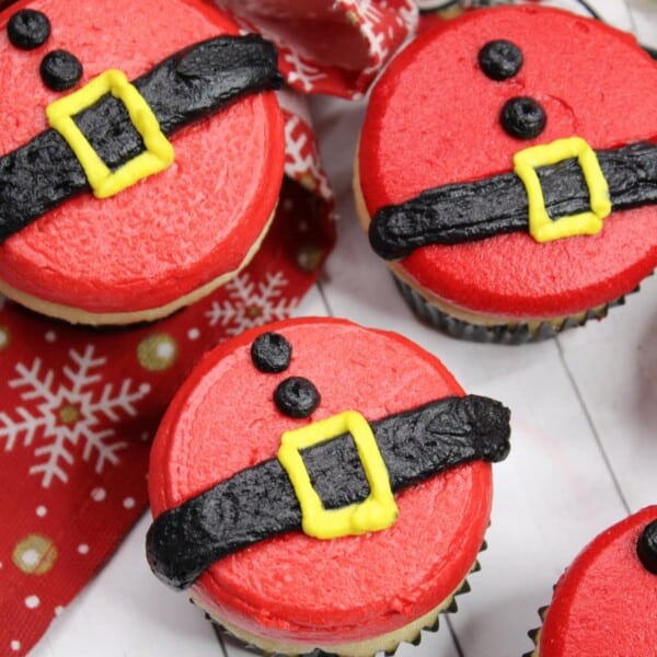 Santa Belly Cupcakes on a Christmas-themed cloth.