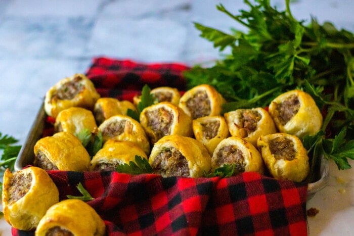 Sausage Rolls in a basket with a plaid blanket.