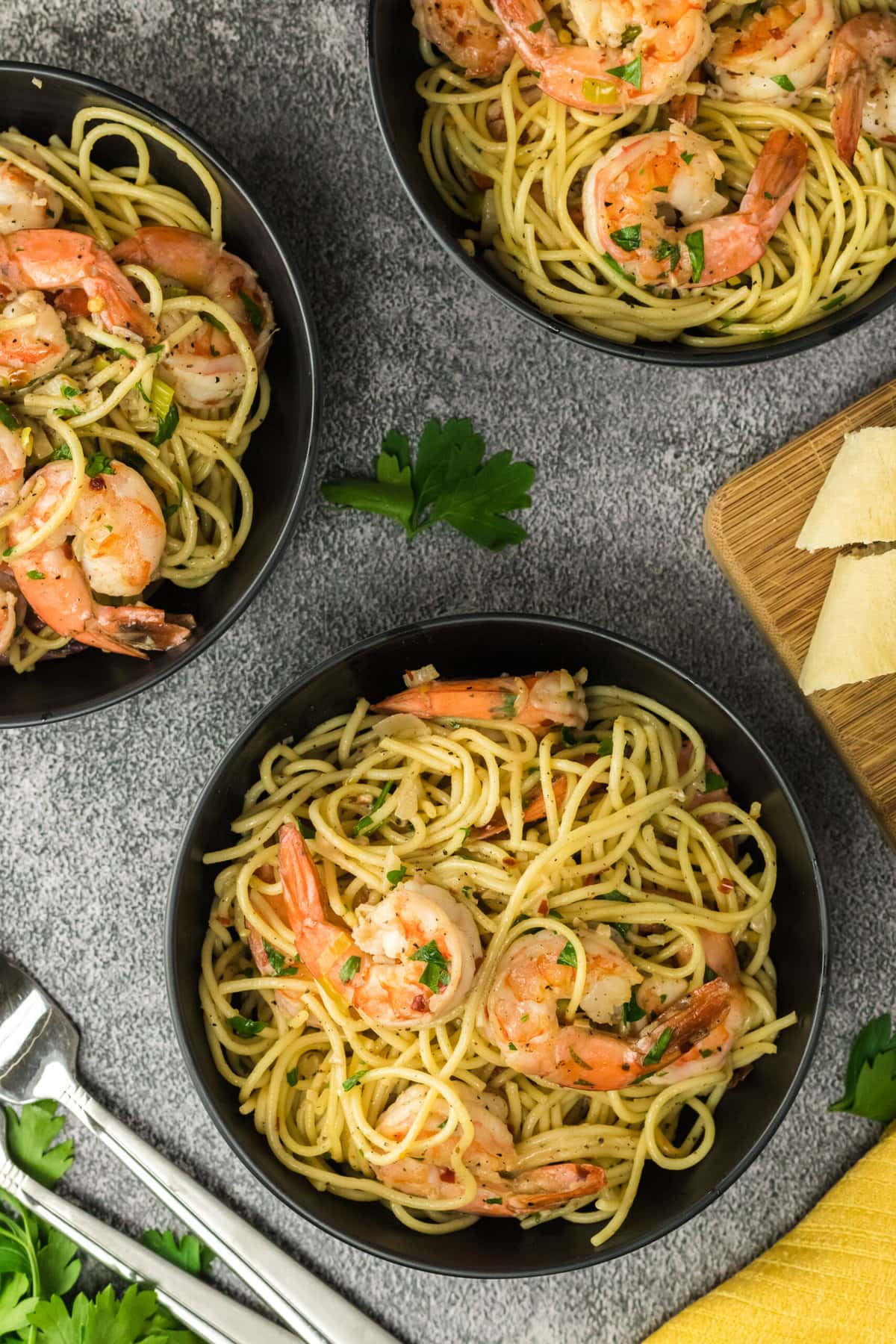 Shrimp Scampi in three separate iron pans.