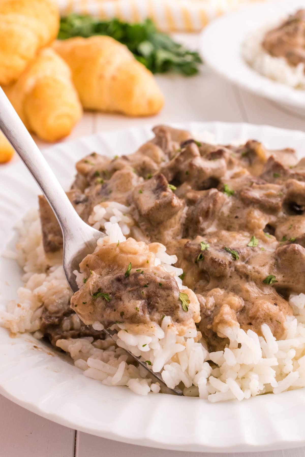 A fork lifting up some of the Beef Tips and Rice.