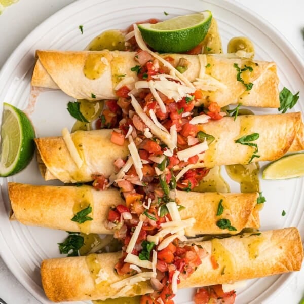 Air Fryer Chicken Taquitos topped with garnishes.