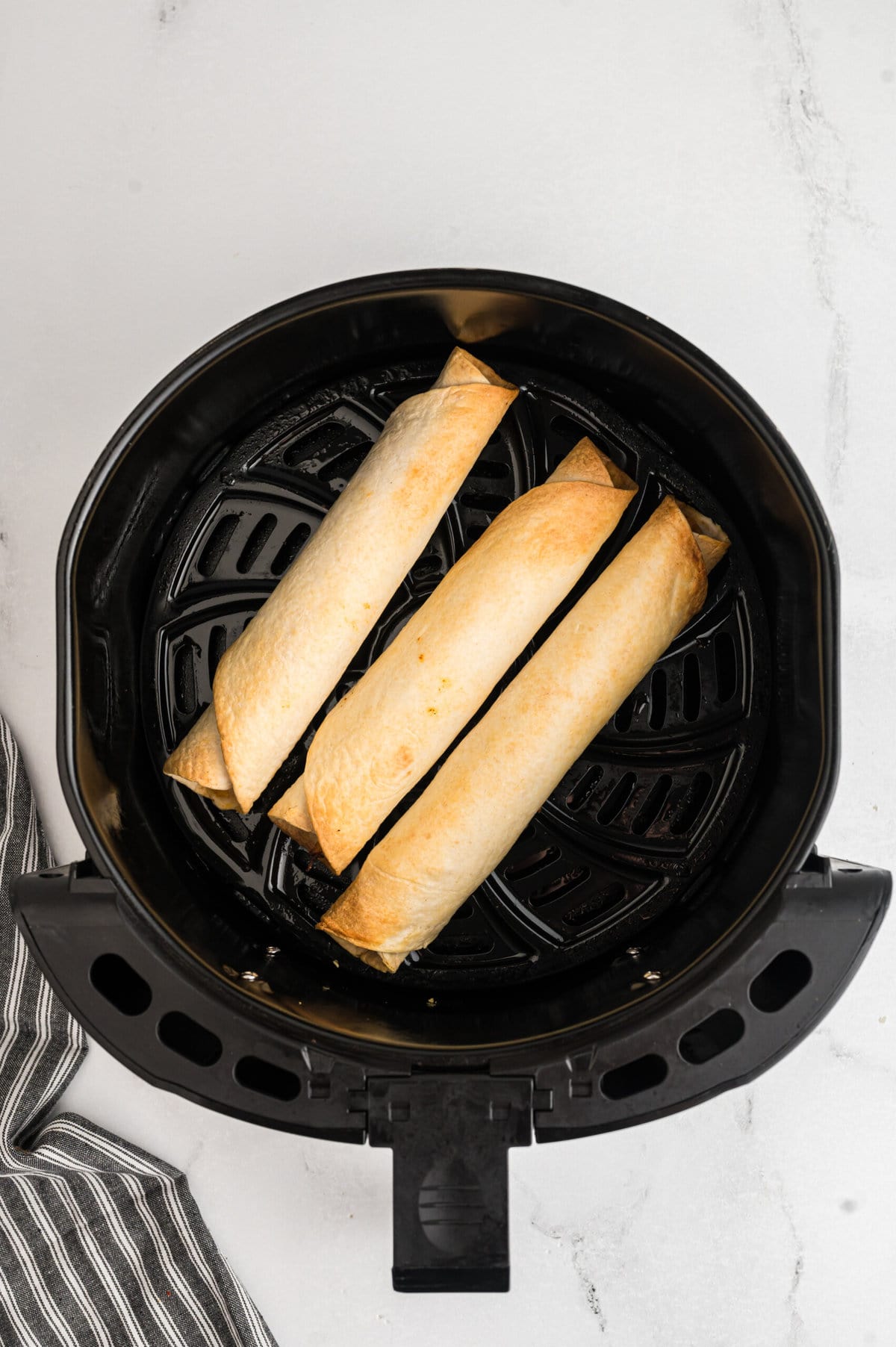 Cooking the Air Fryer Chicken Taquitos.