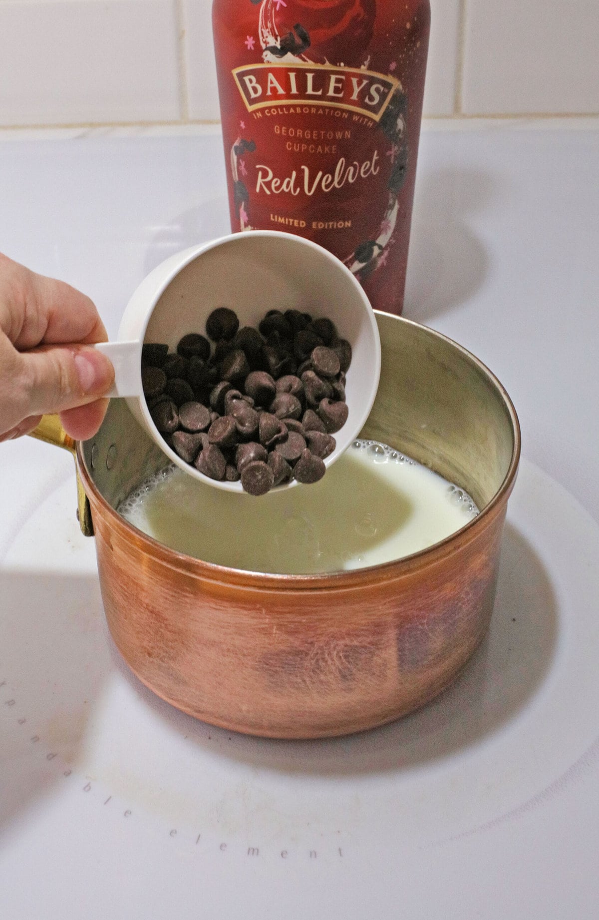 Adding the chocolate chips into the milk.