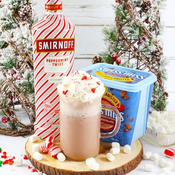 Frozen Peppermint Hot Chocolate with Christmas trees in the back.