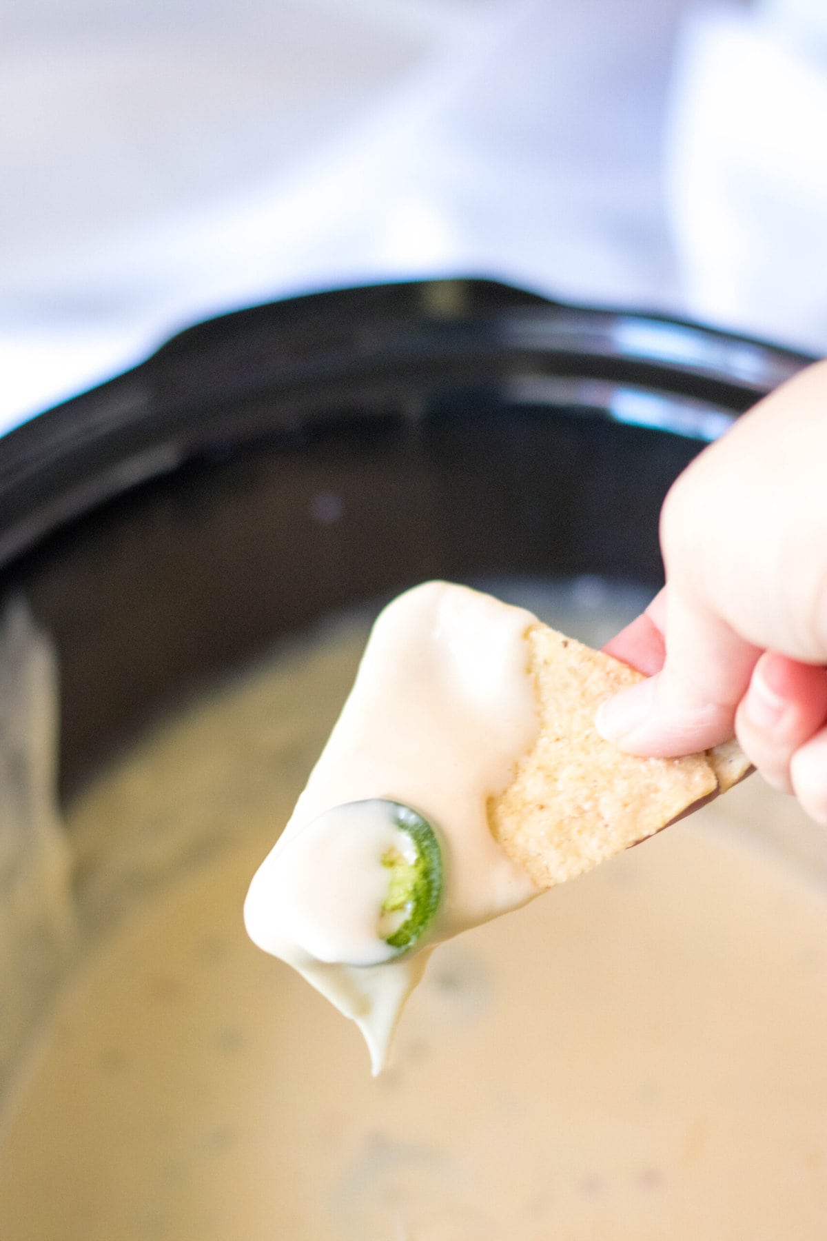 Dipping a chip in the Crockpot Queso.