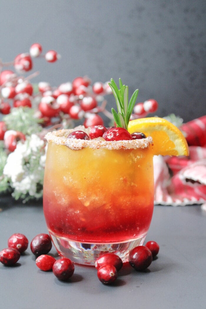 Naughty and Nice Cocktail garnished with fresh cranberries.