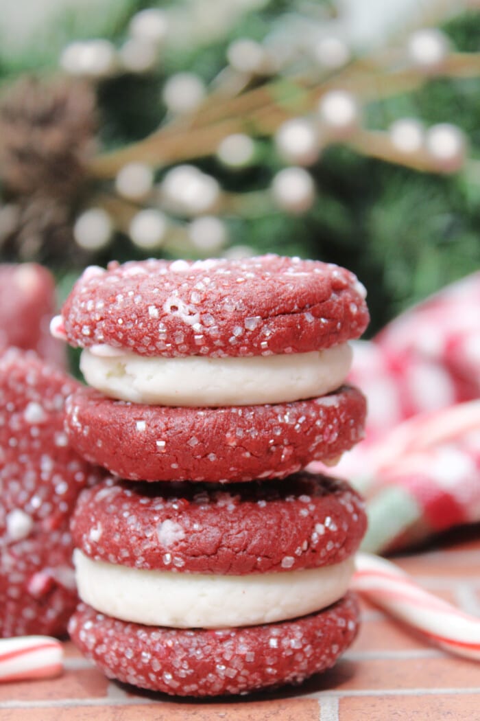 Red Velvet Sandwich Cookies with decorations behind it.