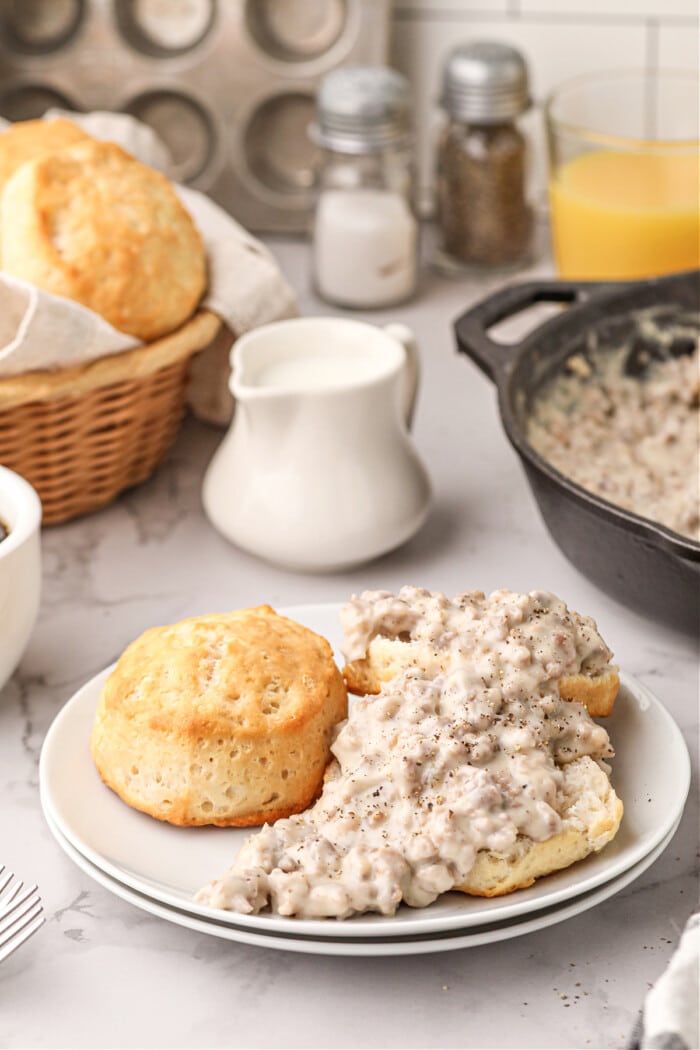 sausage gravy on top of biscuit on white plate