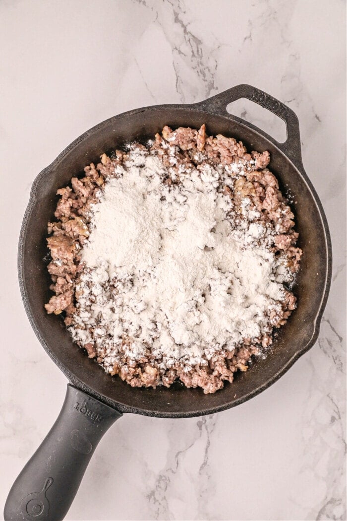 flour on top of cooked sausage in cast iron skillet