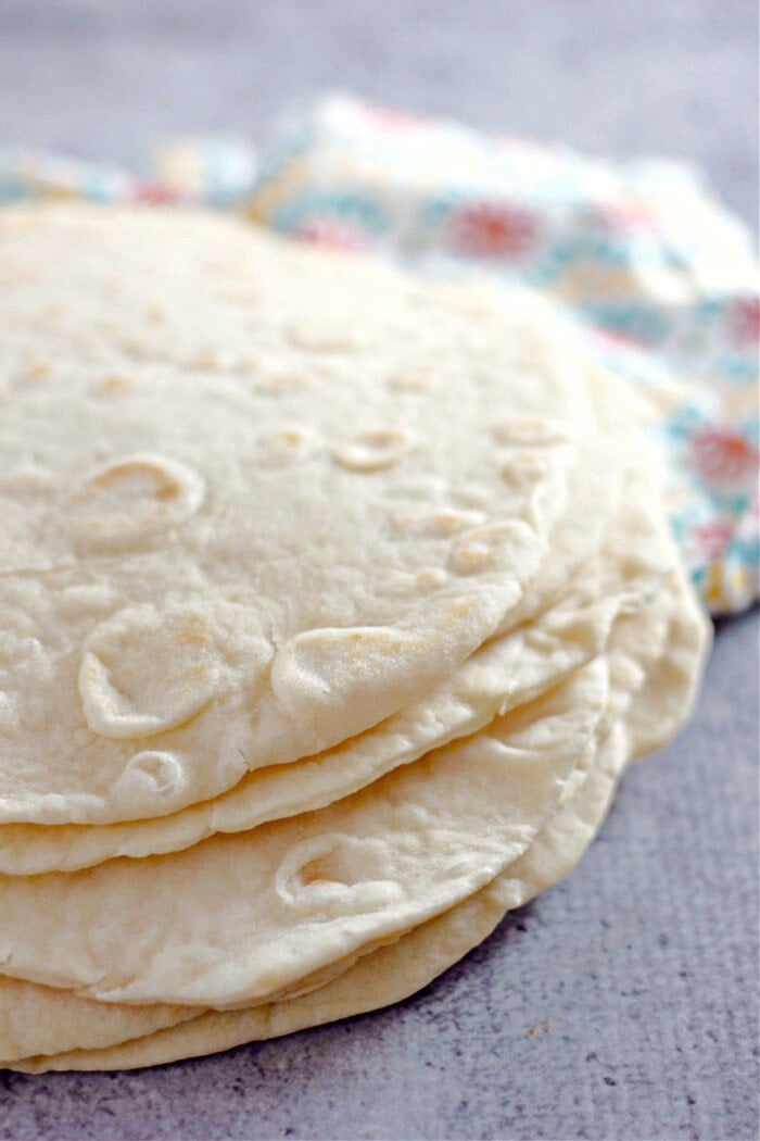 homemade flour tortillas stacked with bright colored napkin