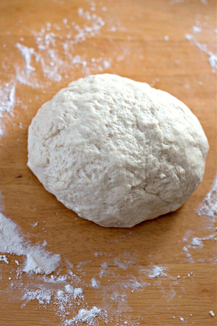 tortilla dough mixed into ball with flour on board