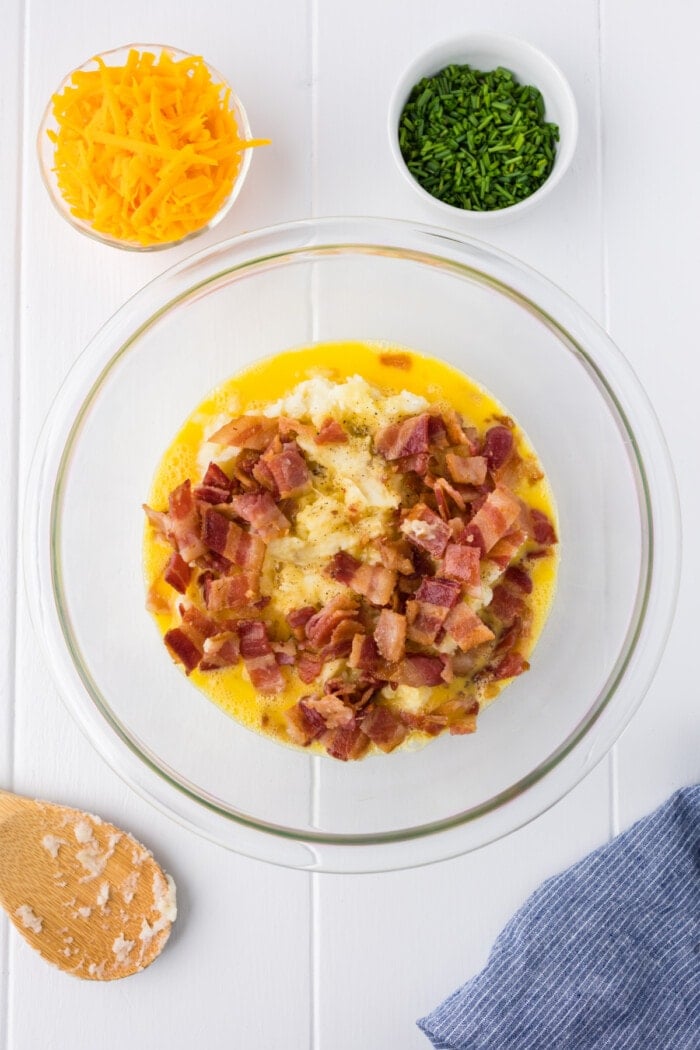 mashed potatoes, eggs and bacon in clear glass bowl