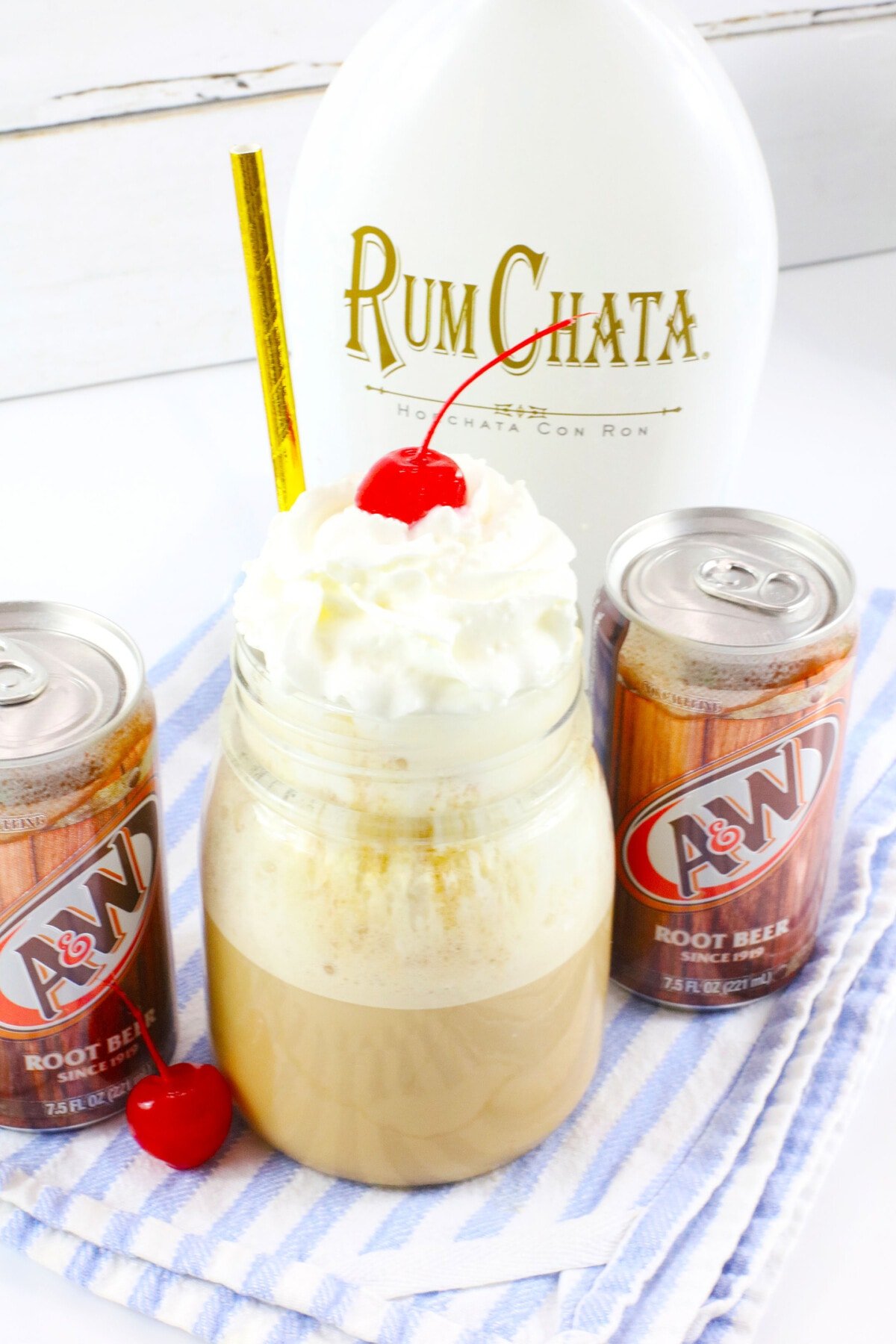 Rum Chata Root Beer Float with two soda cans on the side.
