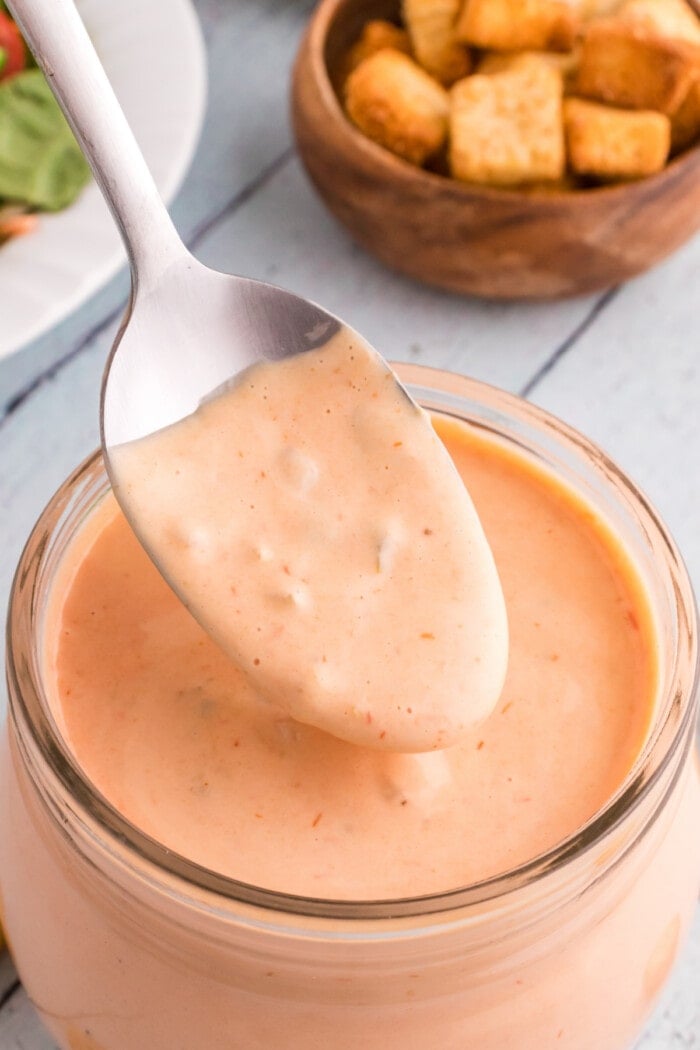 russian dressing on spoon with clear glass jar