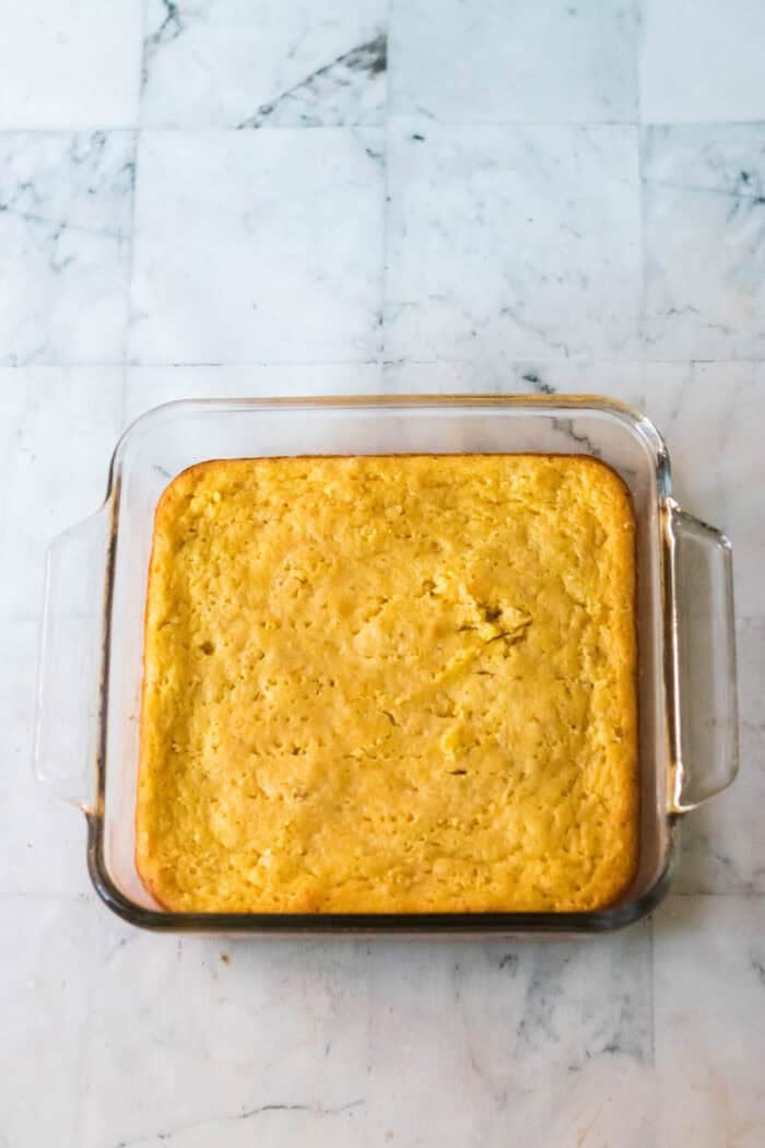 A moist cornbread layer is topped with savory seasoned ground beef, enchilada sauce, and cheese in this tamale casserole recipe. Baked cornbread in a glass baking dish