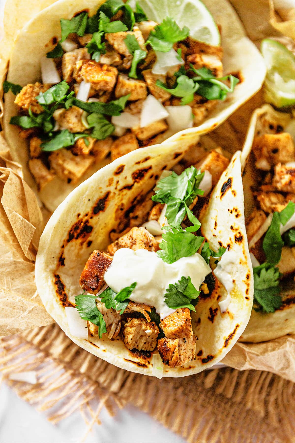 tacos with chicken and topped with cilantro and sour cream