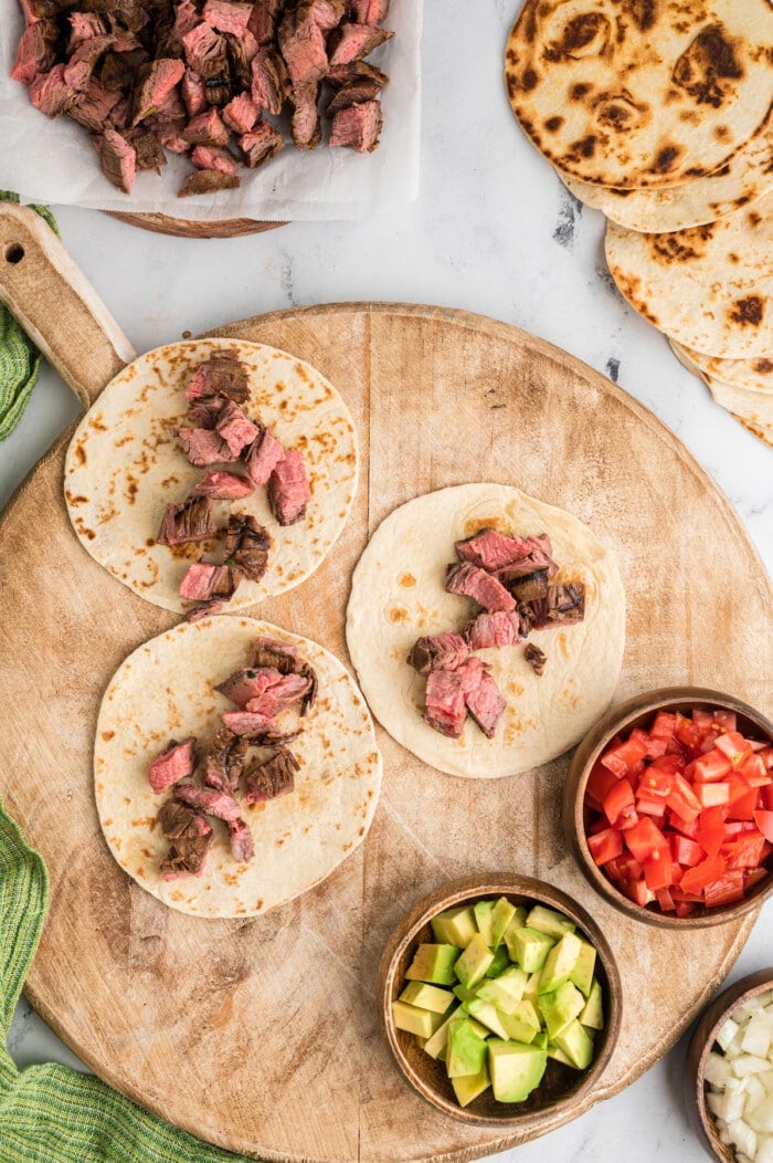 Flour tortillas topped with steak