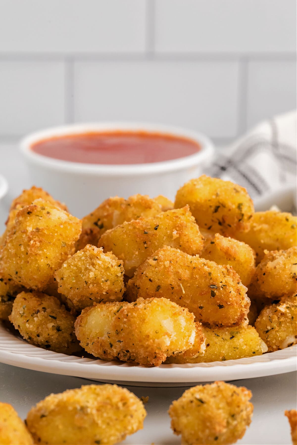 homemade cheese curds in white plate with marinara dipping sauce
