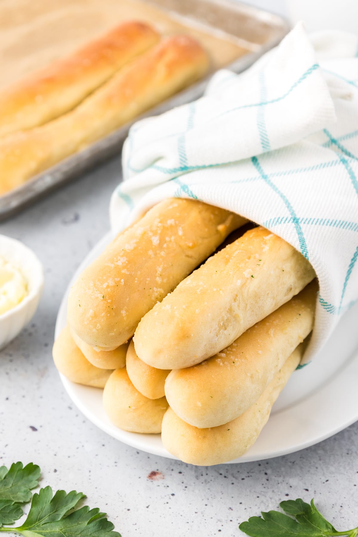 Homemade Olive Garden breadsticks wrapped in a towel on a plate