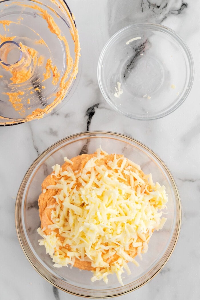 shredded cheddar cheese with pimento cheese in clear glass bowl