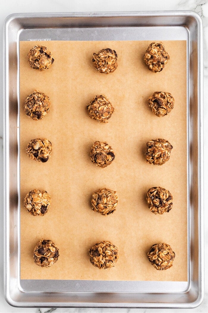 protein balls on baking sheet with brown parchment paper