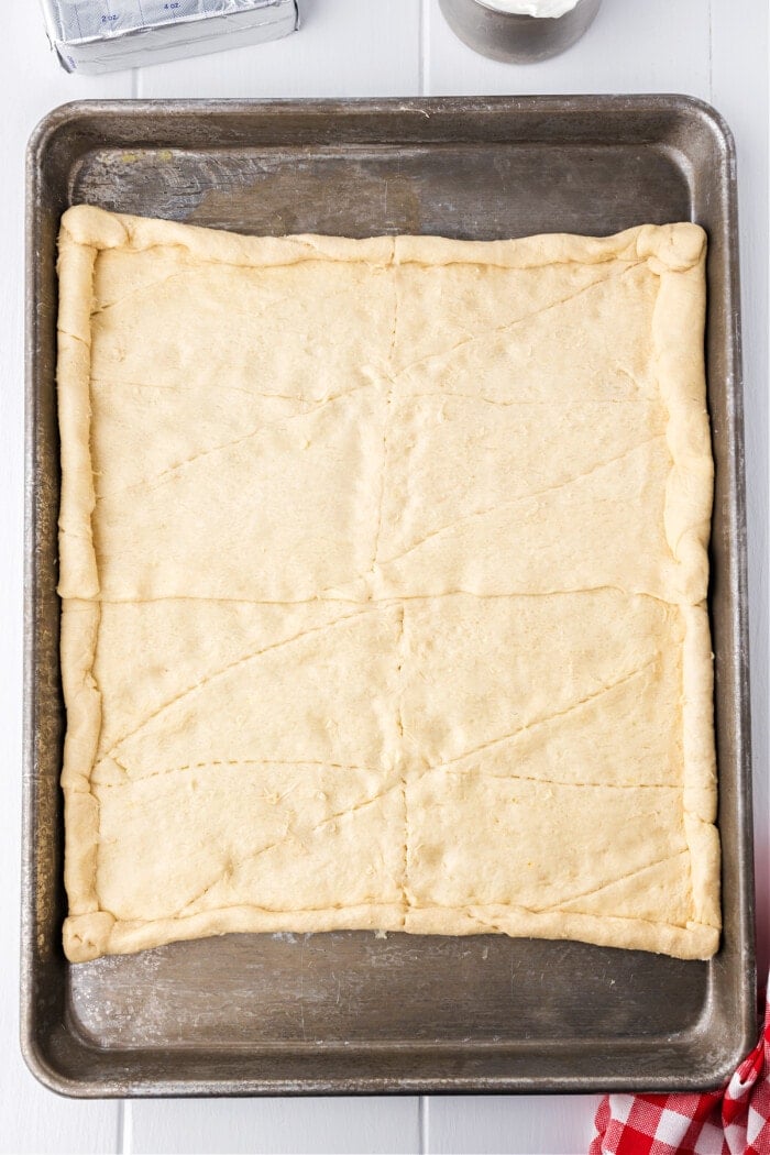 crescent rolls spread onto baking pan for pizza