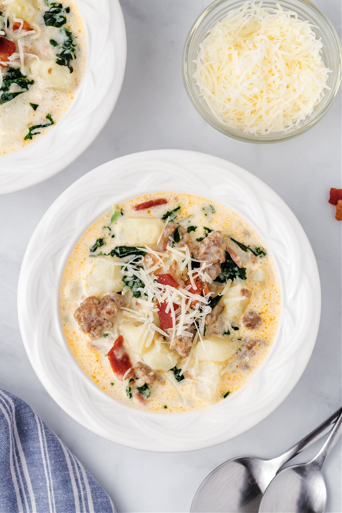 zuppa soup in white bowl with shredded cheese on top