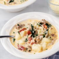 zuppa toscana soup in white bowl with spoon