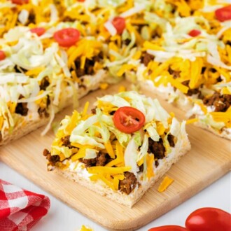 taco pizza cut into squares on cutting board