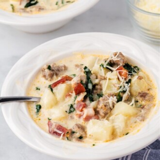 zuppa toscana soup in white bowl with spoon