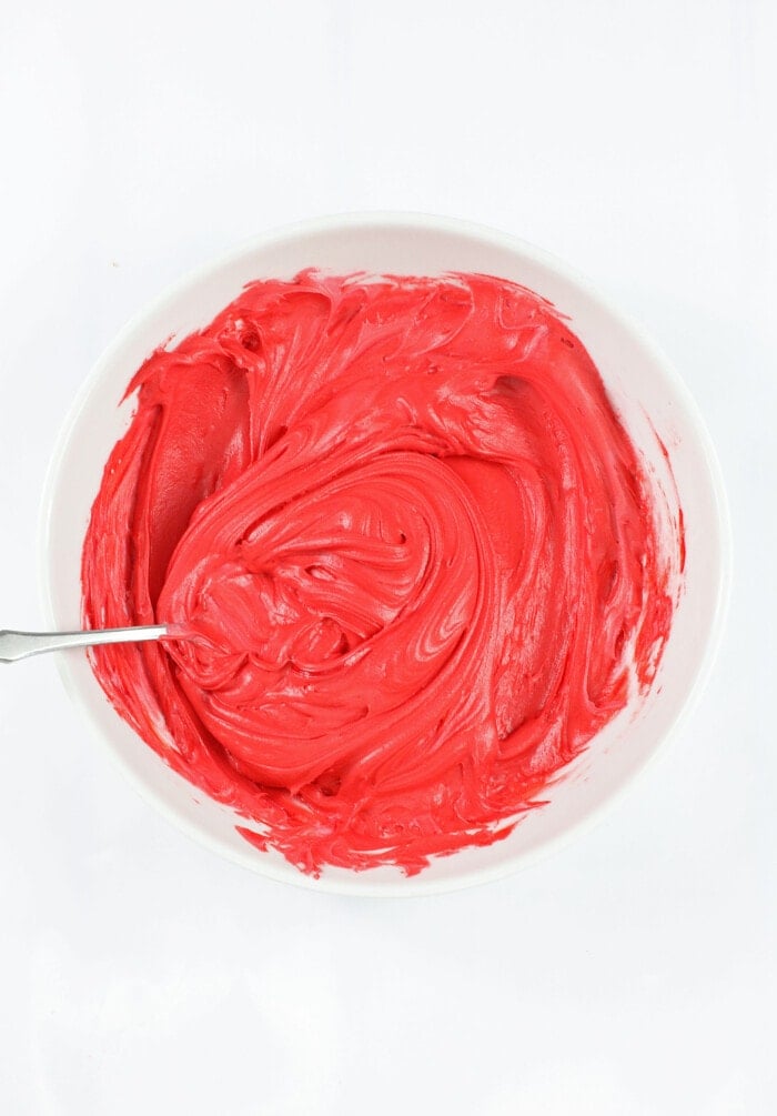 Adding the food coloring into the frosting.