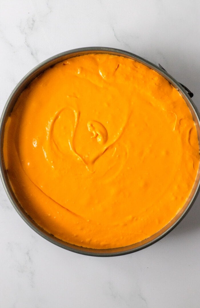 Adding the Carrot Cheesecake batter into the pan.