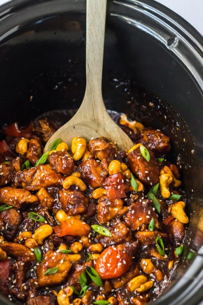 A spoon lifting up some of the Crockpot Cashew Chicken.