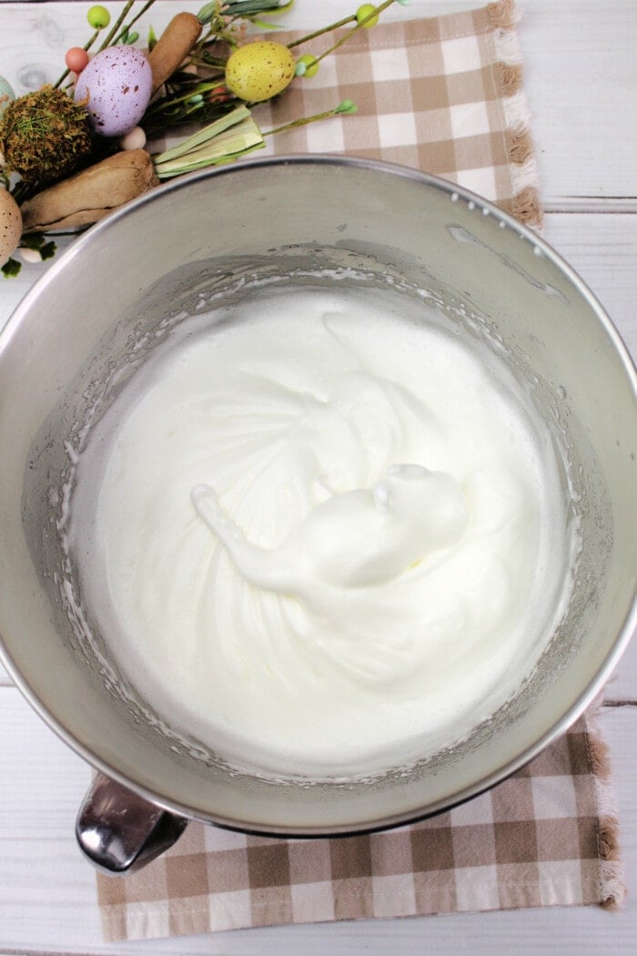Whisking the egg mixture into soft peaks.
