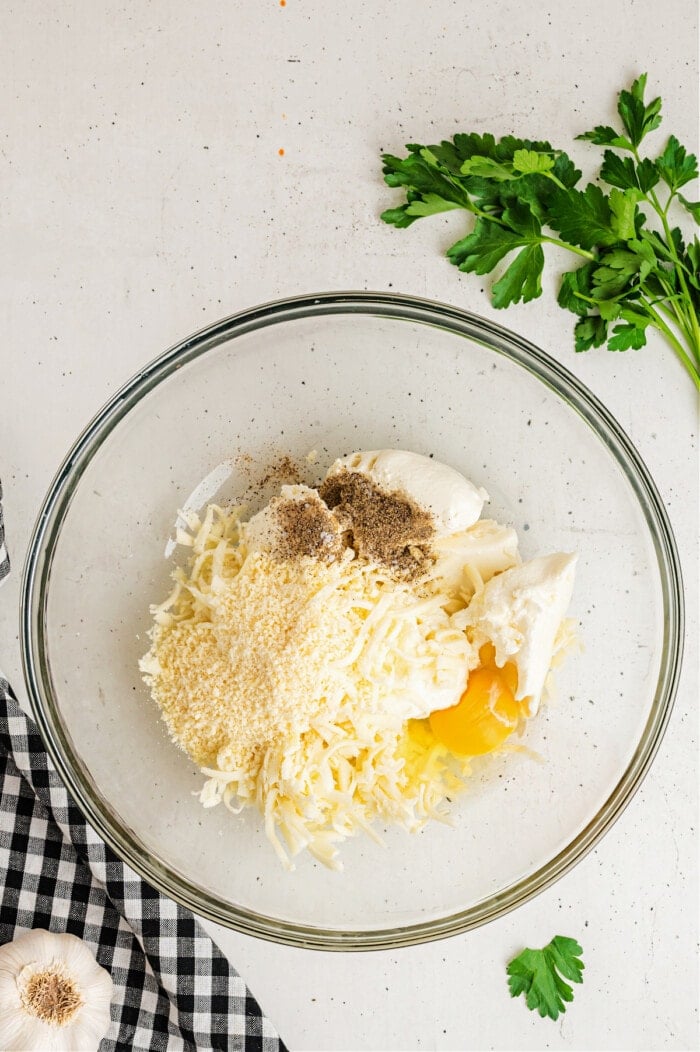 cheese, egg and spices in clear glass bowl