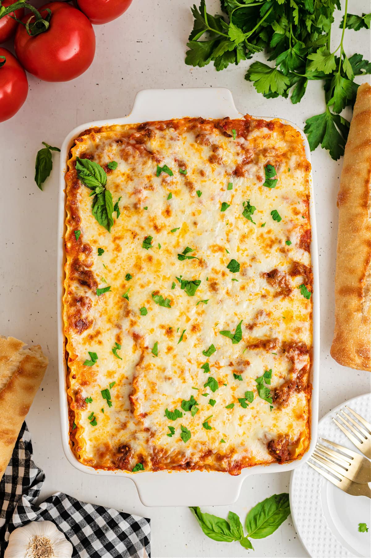cooked lasagna in white baking dish with parsley